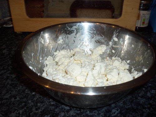 Broken up cheese in a silver bowl